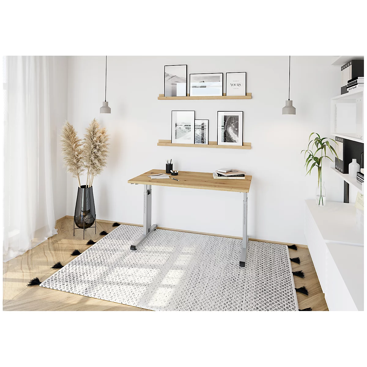 A desk in a modernly furnished room. There are books and pens on the table. Pictures are hanging on the wall. A rug covers the floor.