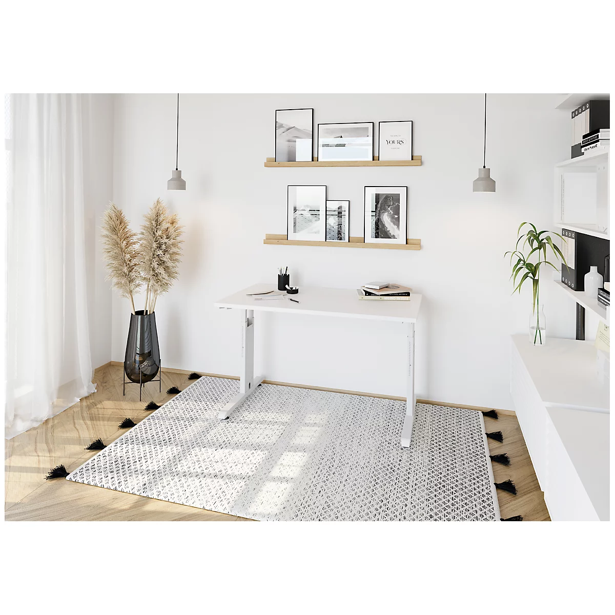 Bright desk in front of white wall, pictures, lamps and a carpet. Paper and pens on the table. A decorative bouquet in a vase.