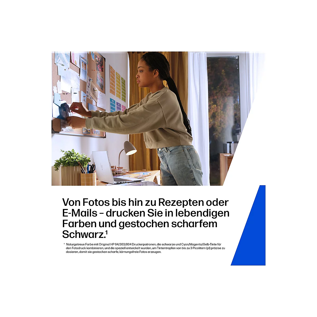 Junge Frau befestigt Fotos an einer Pinnwand über einem Schreibtisch mit Laptop und Lampe.