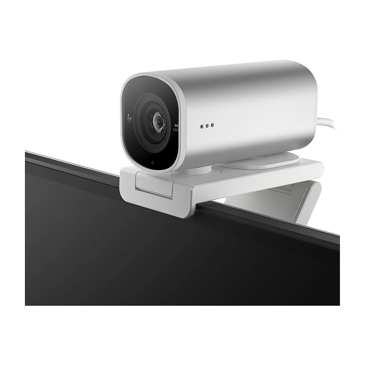 Nahaufnahme einer silbernen Webcam, die an einem schwarzen Monitor befestigt ist. Das Objektiv ist groß und rund, mit der Aufschrift 4K UHD. Der Halter ist weiß.