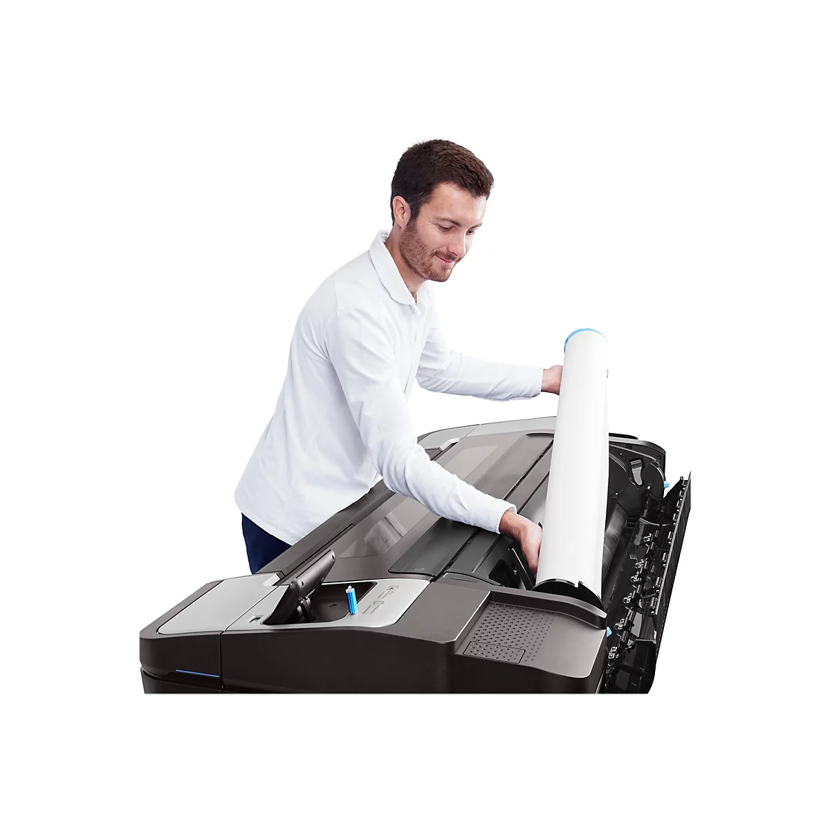 Ein Mann in weißem Hemd lädt Papierrolle in Großformatdrucker ein. Lächelt.