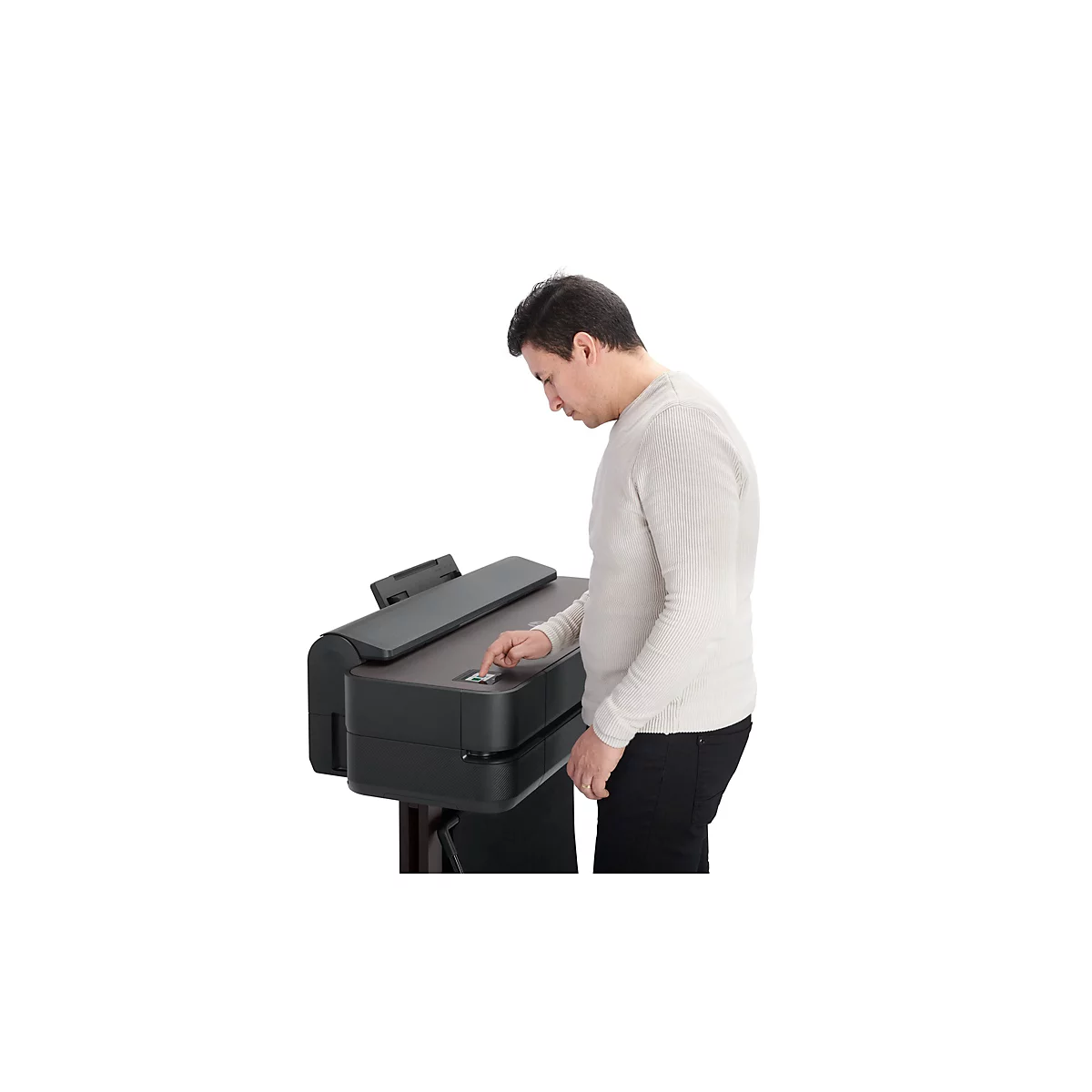 Un homme utilise une imprimante grand format. Il appuie sur un bouton.