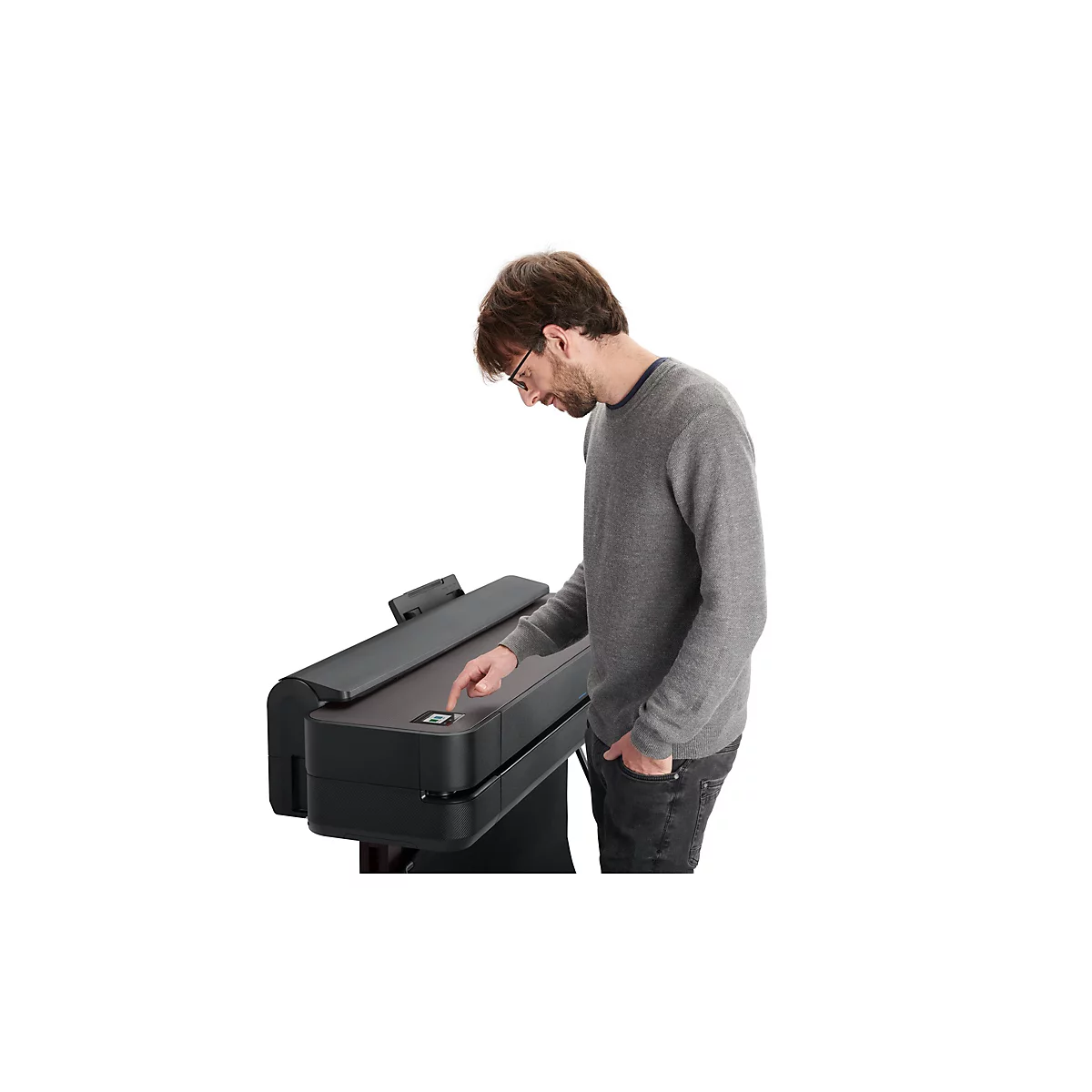 Ein Mann mit Brille bedient einen Drucker; er drückt auf ein Bedienfeld.
