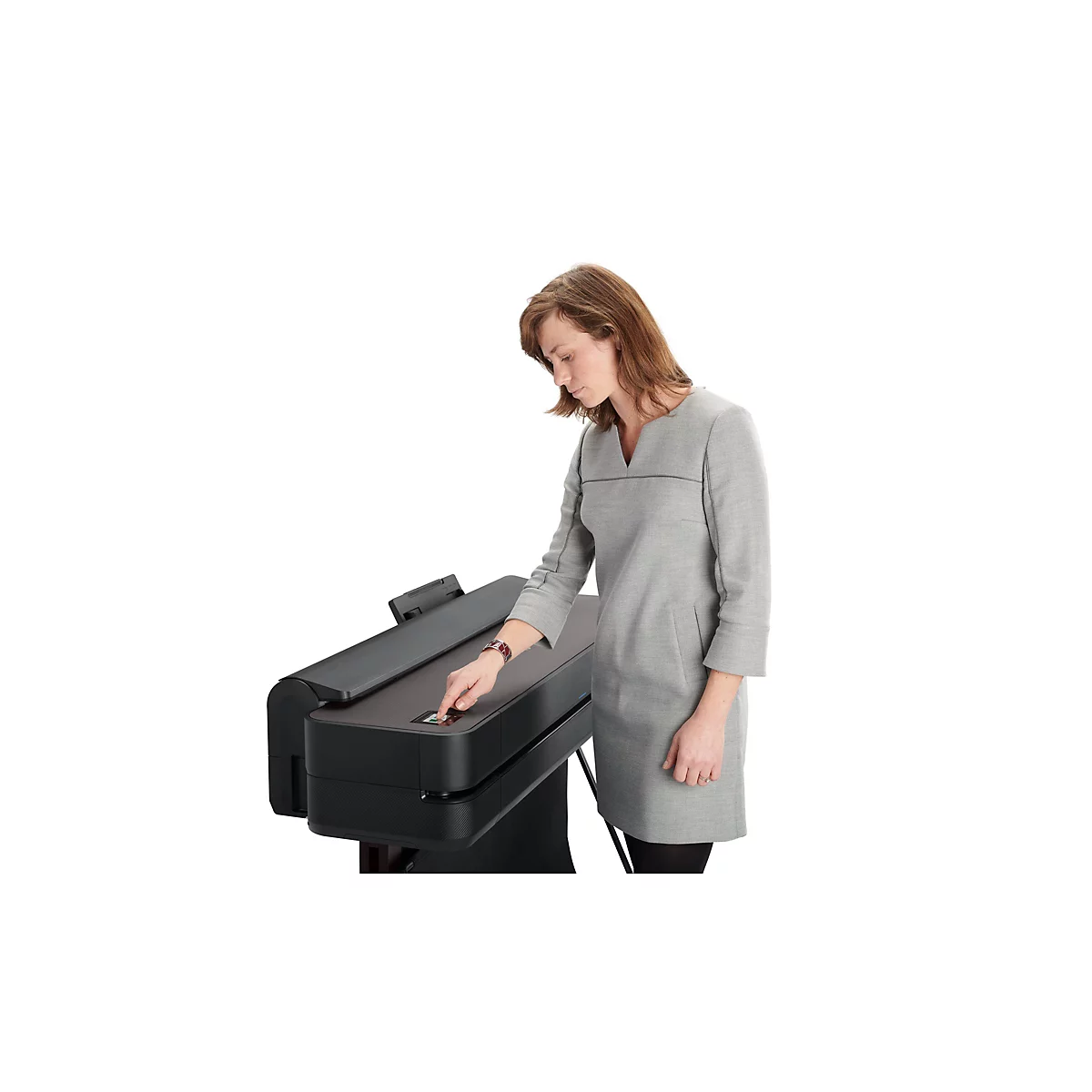 Eine Frau in grauem Kleid drückt einen Knopf an einem Drucker. Sie steht vor weißem Hintergrund.