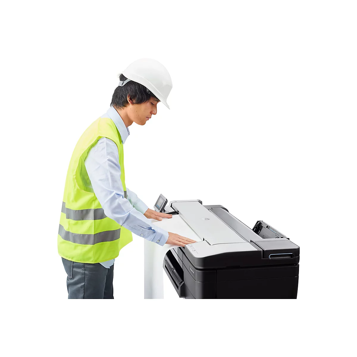 Ein Mann mit Helm und Warnweste bedient einen grossen Drucker.
