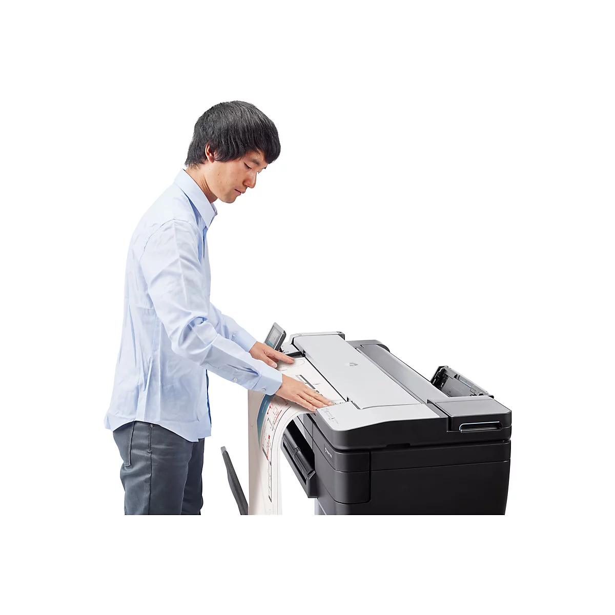 Ein Mann bedient einen GroÃŸformatdrucker. Er legt ein groÃŸes Papierdokument ein.