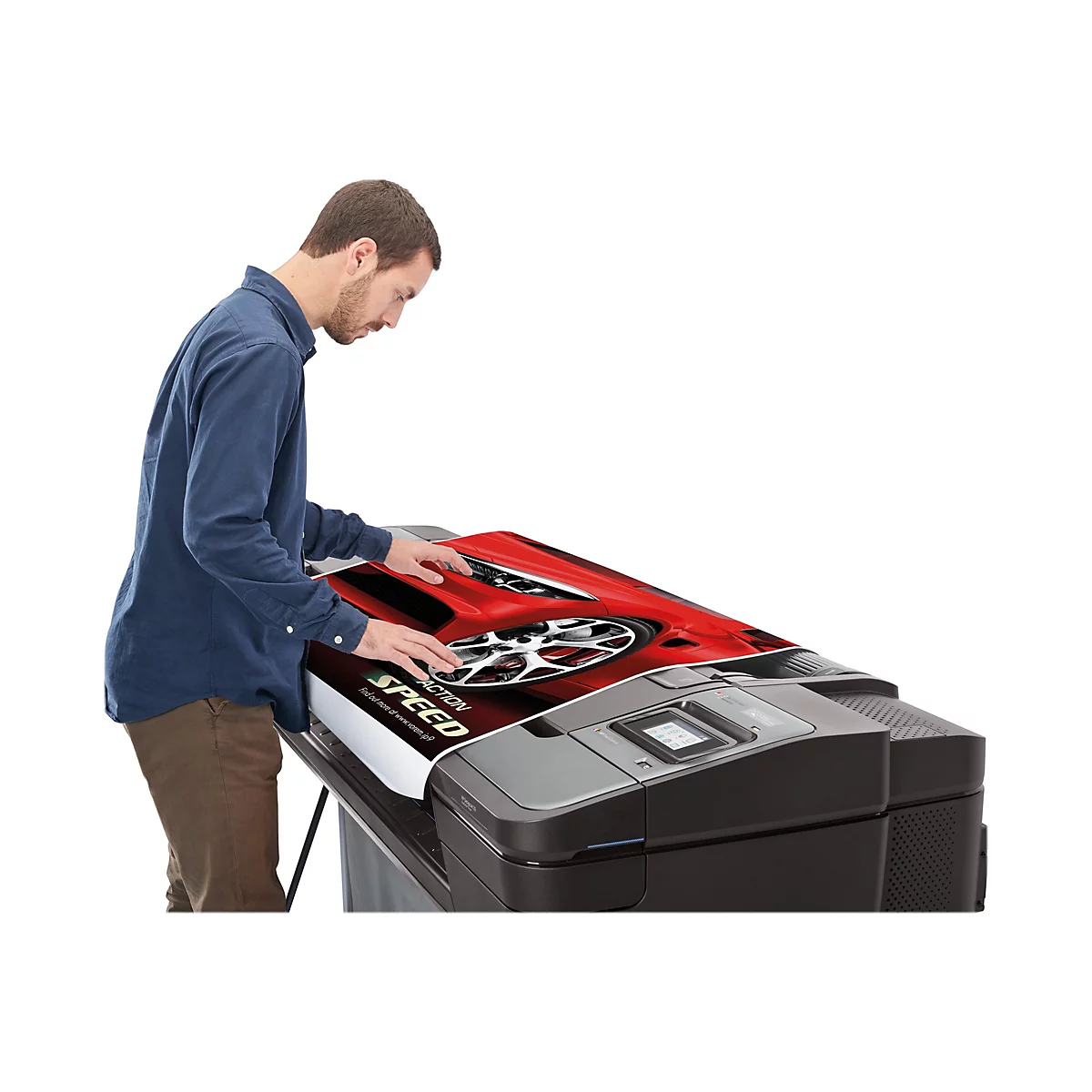 Ein Mann in blauem Hemd bedient einen Großformatdrucker. Er betrachtet das gedruckte Bild eines roten Sportwagens.