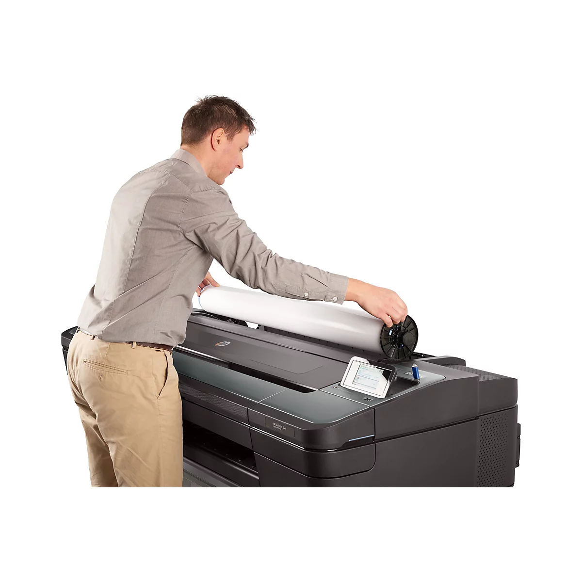 Ein Mann legt eine Papierrolle in einen GroÃŸformatdrucker ein. Er trÃ¤gt ein Hemd und eine Hose.