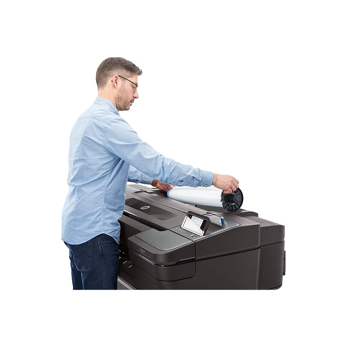 Ein Mann in blauem Hemd legt eine Papierrolle in einen schwarzen Drucker. Er steht vor weiÃŸem Hintergrund.