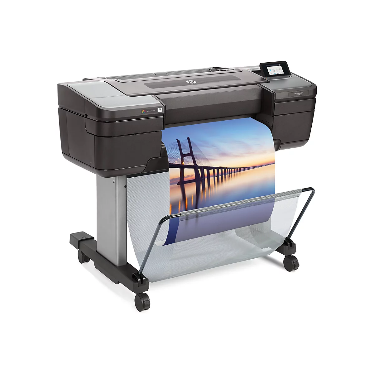 Großer, schwarzer HP-Plotter mit Papierausdruck: Brücke am Meer bei Sonnenuntergang. Der Plotter steht auf Rollen.