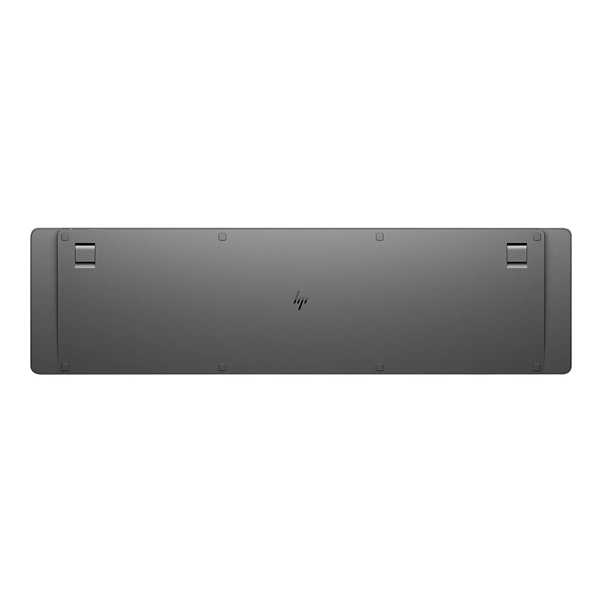 Die Unterseite einer grauen HP-Tastatur mit zwei ausklappbaren Standfüßen und dem mittigen HP-Logo.