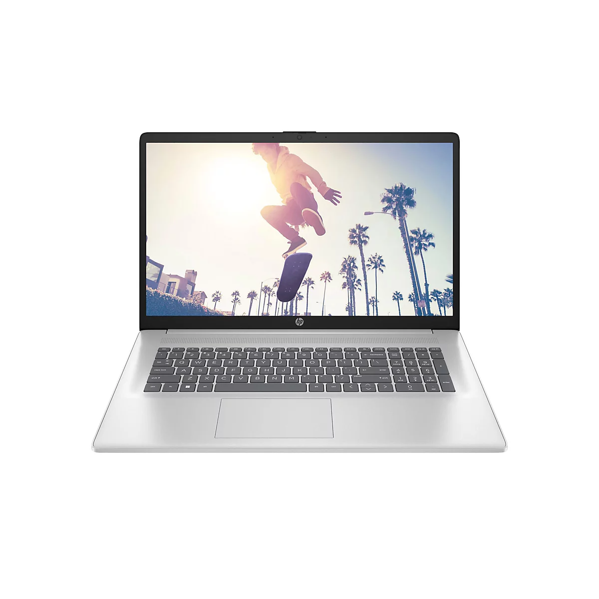Ein silberner Laptop, auf dessen Bildschirm ein Skateboarder in der Luft vor Palmen zu sehen ist.