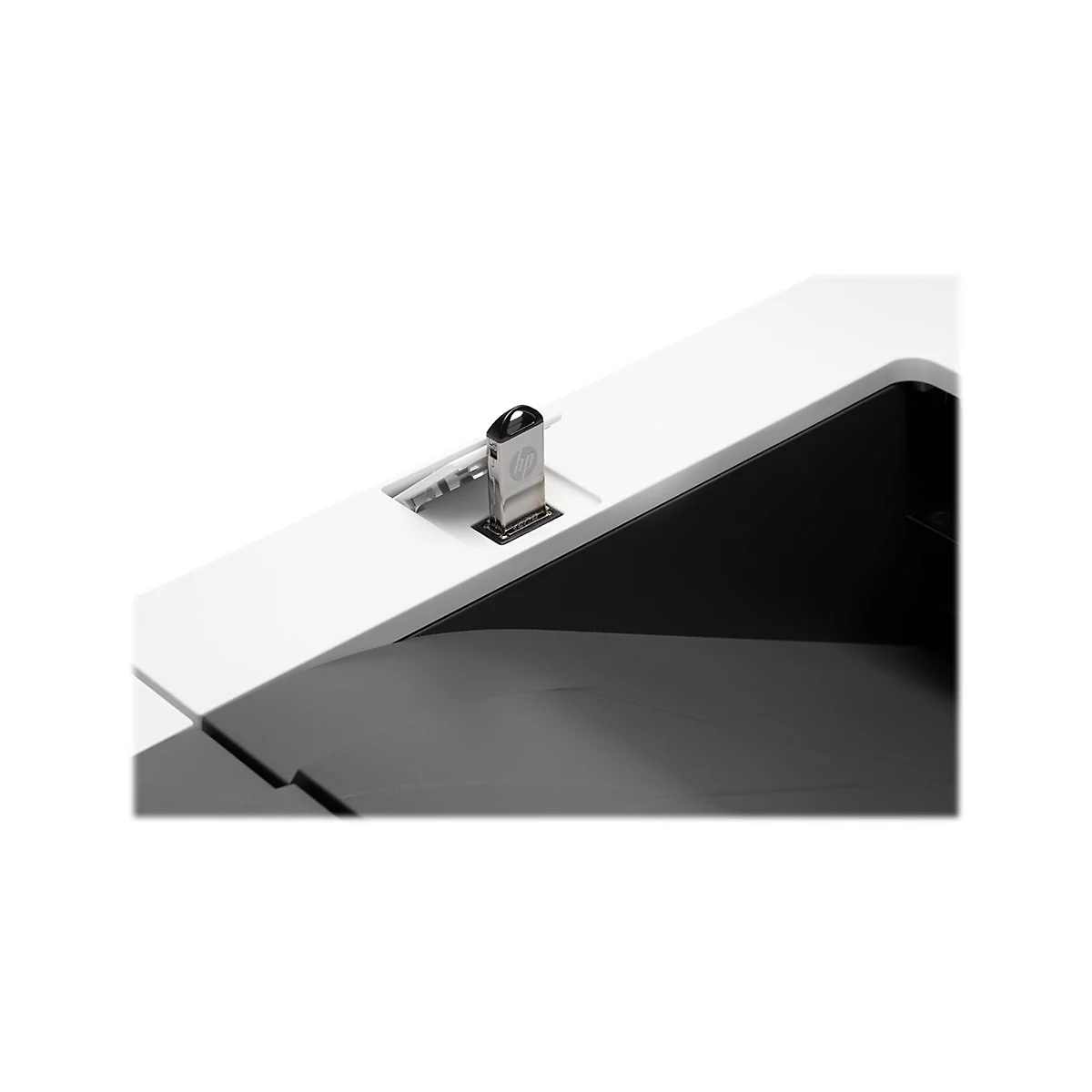 Nahaufnahme einer silbernen USB-Verbindung, die in einen weiÃŸen Schreibtisch eingesetzt ist. Der Schreibtisch hat eine schwarze, gewÃ¶lbte Kante.