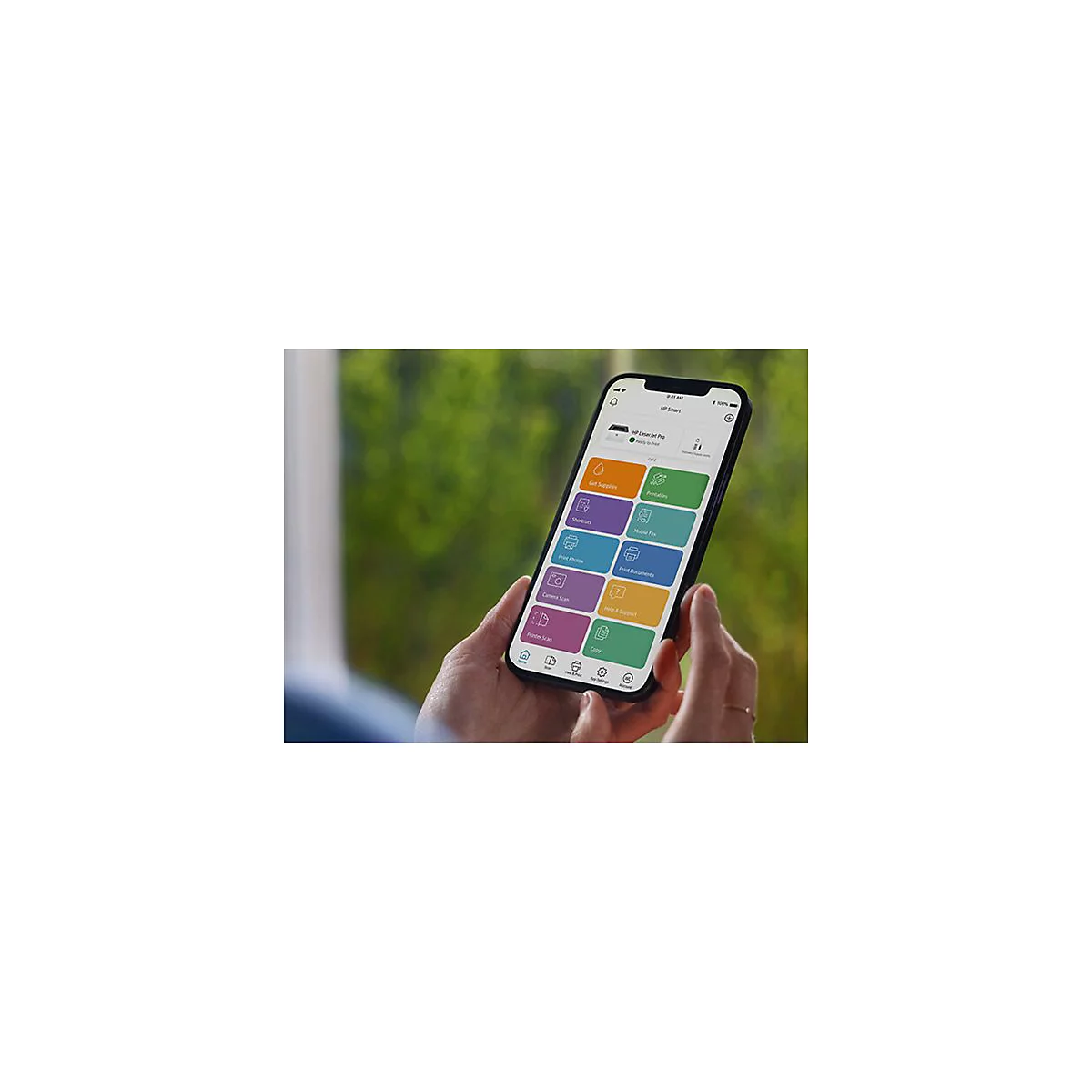 Person hält Smartphone mit HP Smart App. App-Icons: Zubehör besorgen, Druckbares, Shortcuts, Mobile Fax, Fotos drucken, Dokumente drucken, Kamera scannen, Hilfe & Support, Drucker scannen, Kopieren.