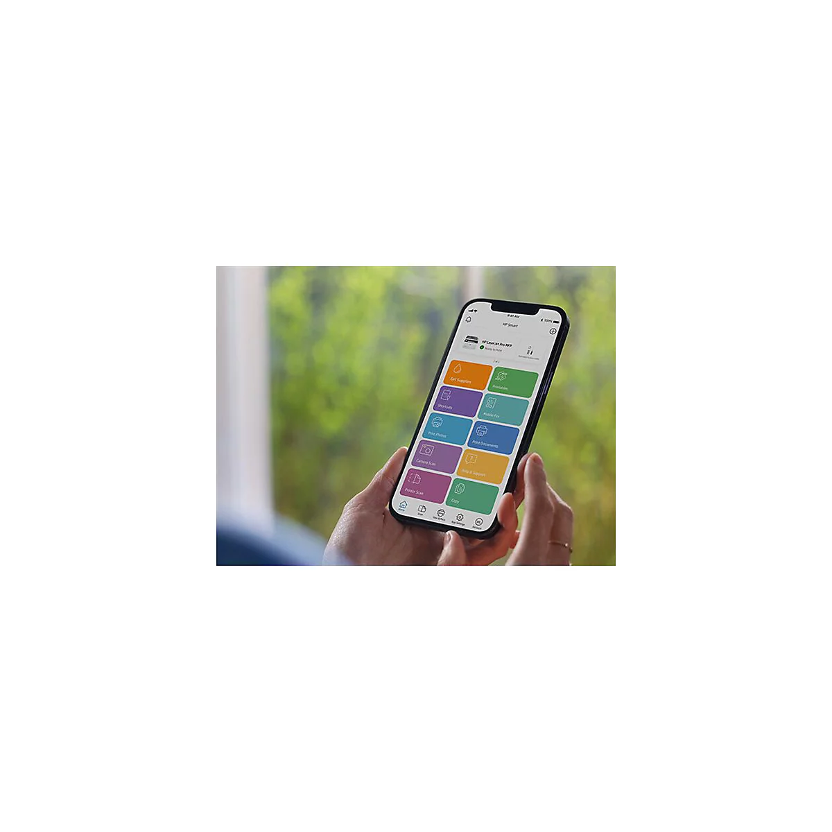 Hände halten ein Smartphone mit HP Smart App. Auf dem Bildschirm sind App-Optionen zu sehen.
