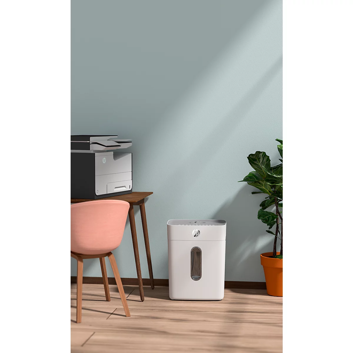 Office with shredder and printer. A chair is on the left. A plant in a pot on the right.
