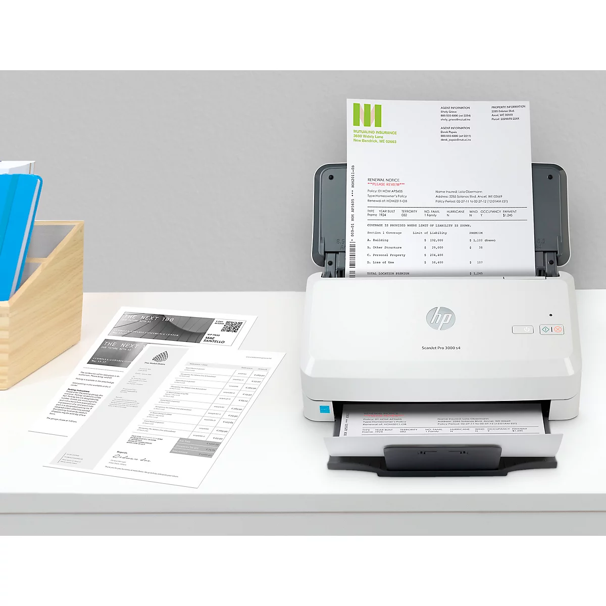Scanner HP blanc avec documents sur une table blanche. Un papier est en cours de numérisation.