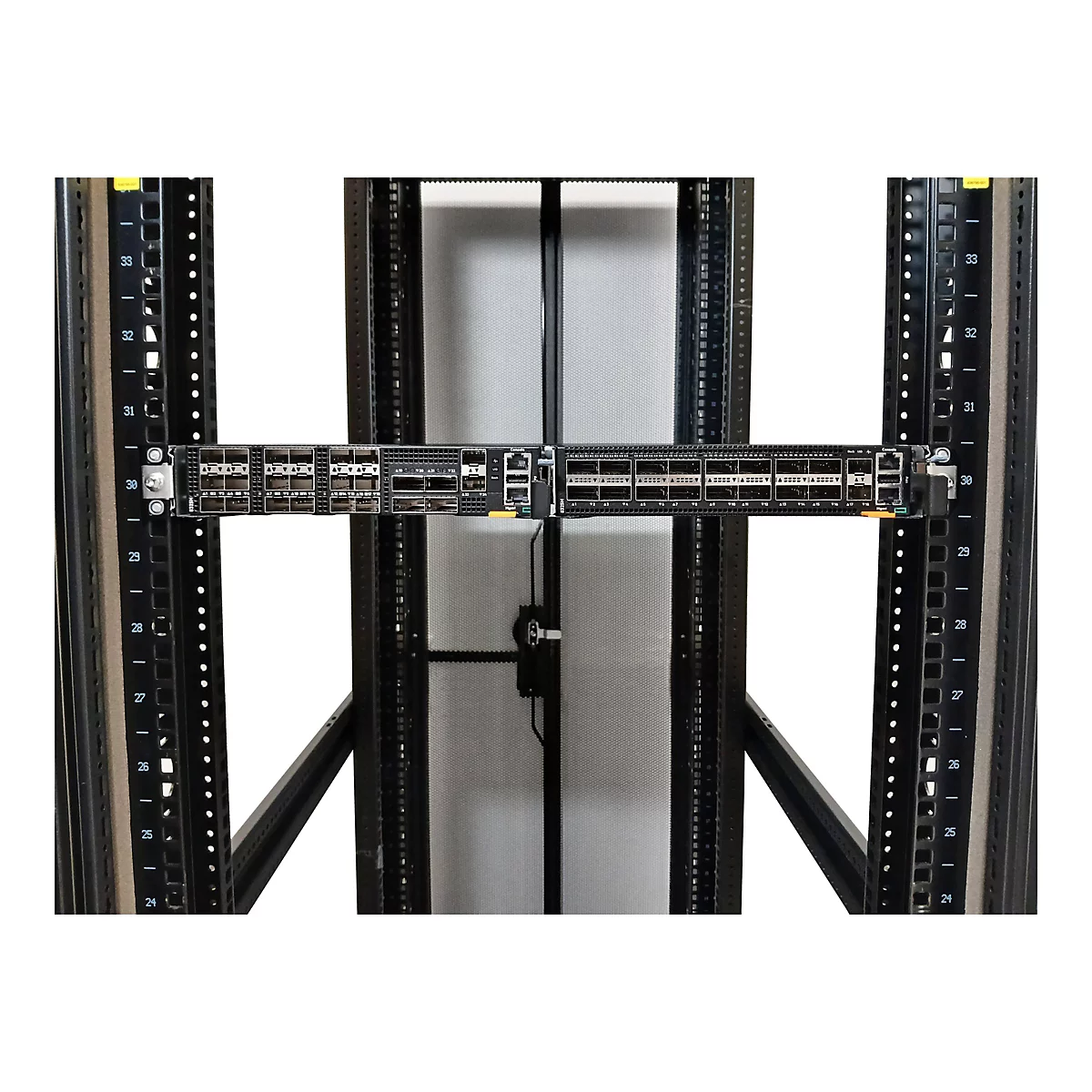Ein schwarzer Netzwerkschalter in einem Serverschrank mit vielen Anschlüssen.