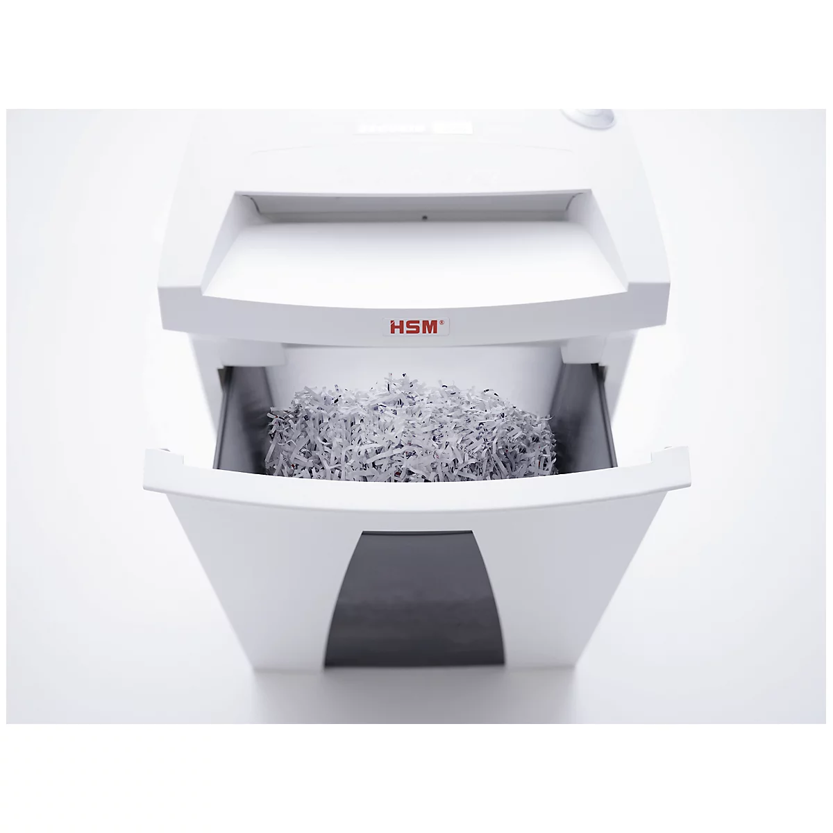 White paper shredder with open drawer filled with shredded paper. Reads "HSM".