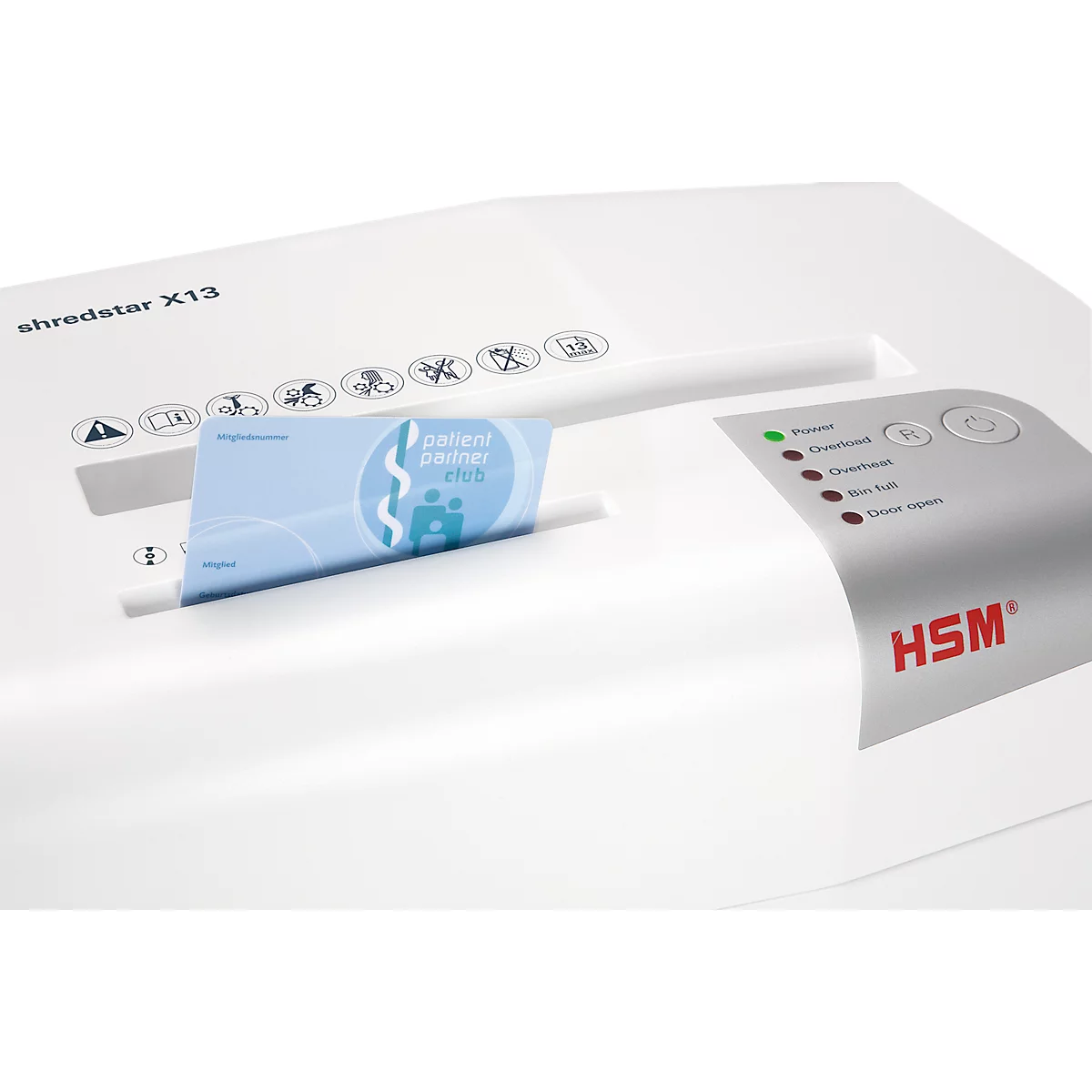 A white paper shredder shreds a blue card. There are buttons and indicators on the device.
