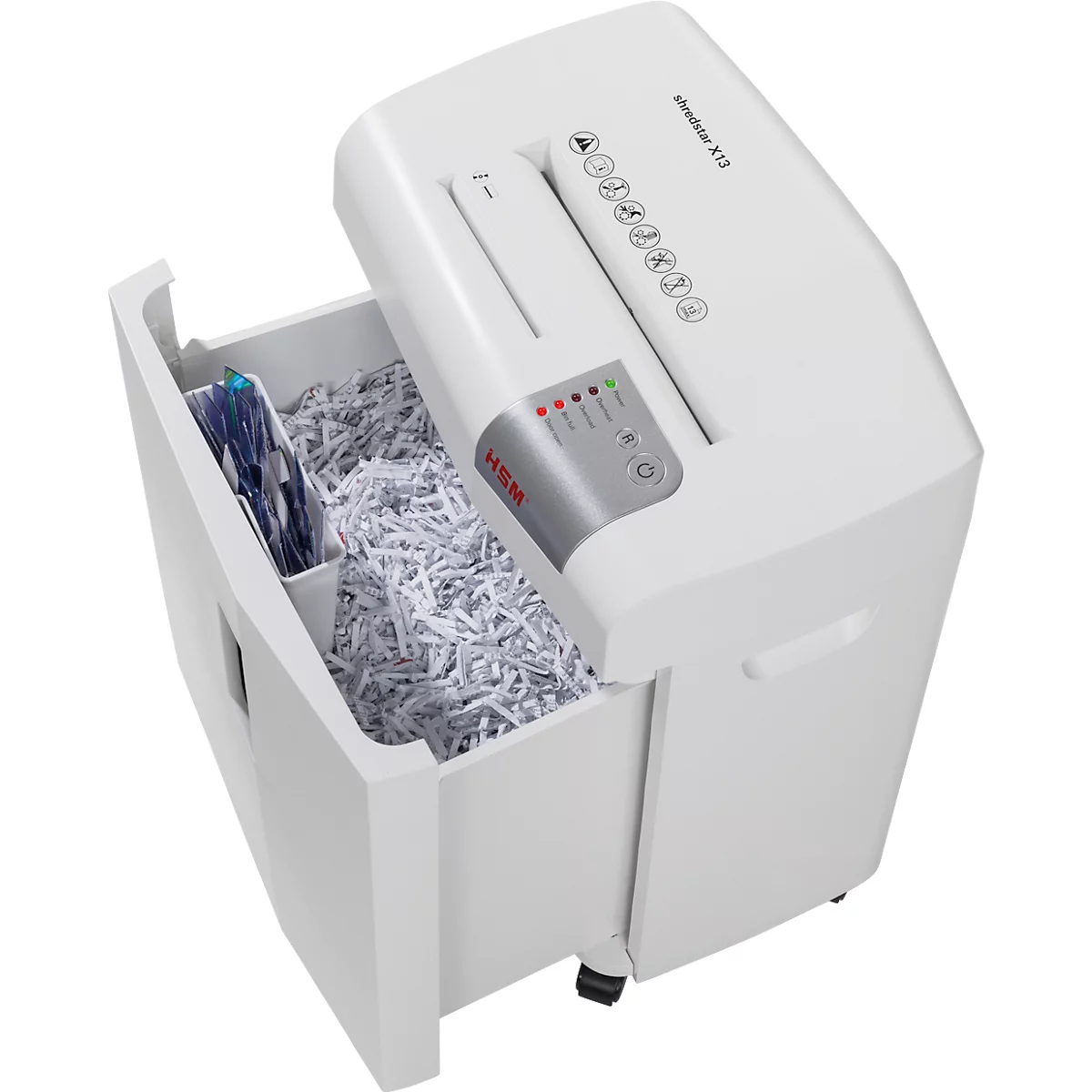 White paper shredder with open collection container. Shredded paper and blue documents inside.