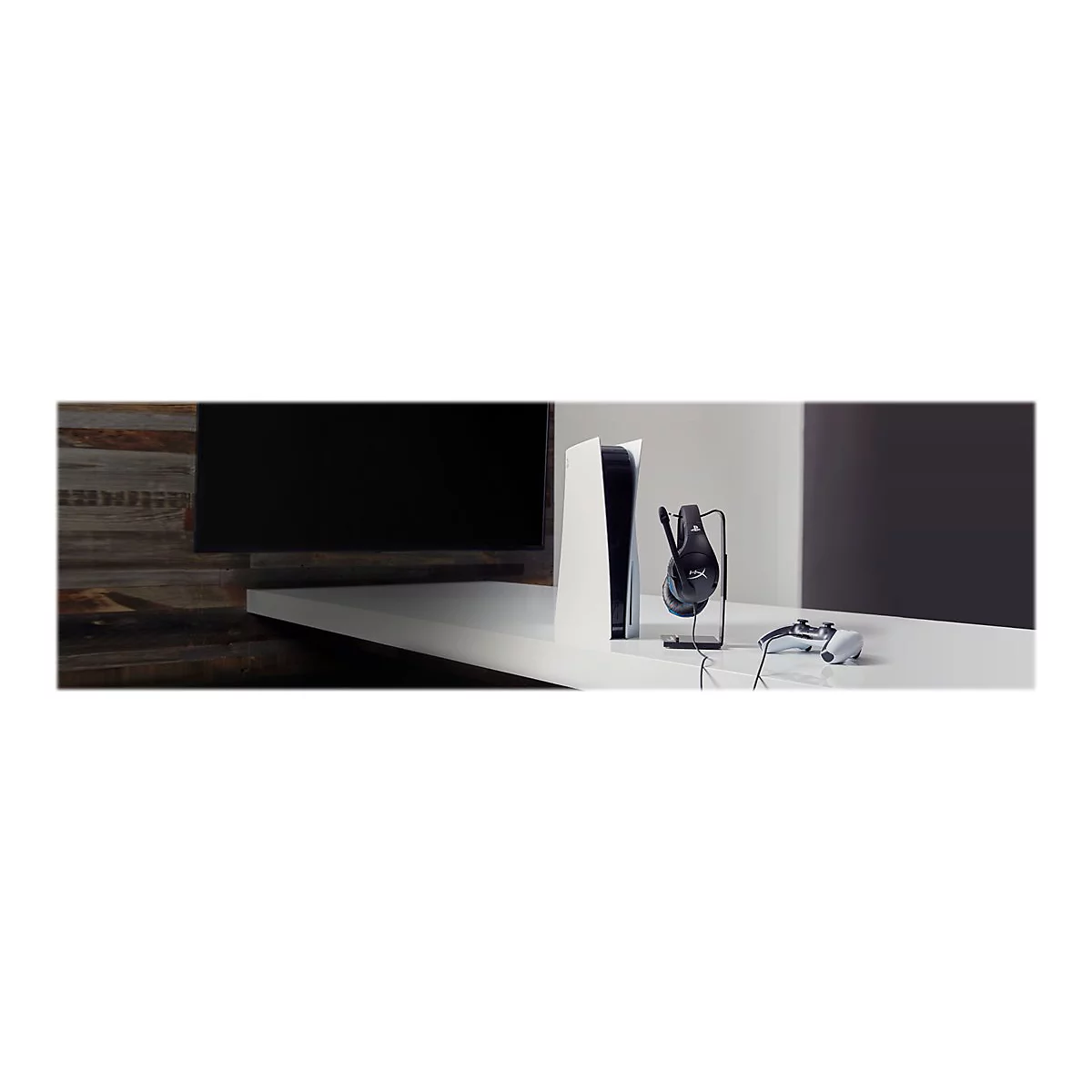 Eine weiÃŸe Playstation 5 mit Headset, Controller und Halterung auf einem Tisch.