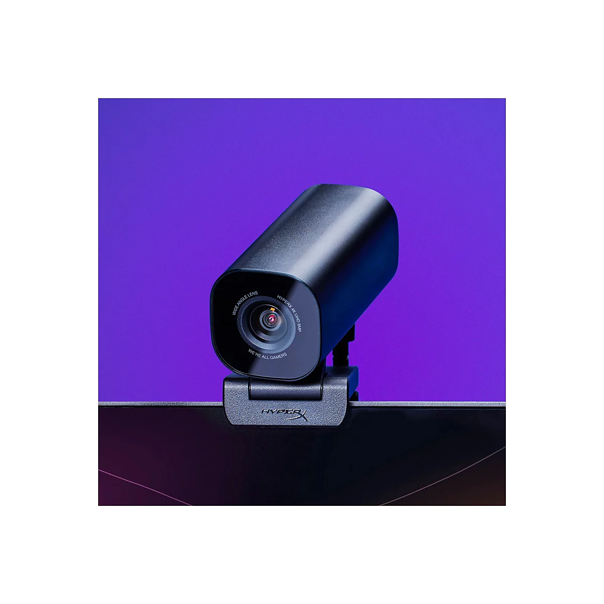 Une webcam noire avec les mots "HYPERX 4K UHD 8MP" et "WE'RE ALL GAMERS" devant un fond violet.