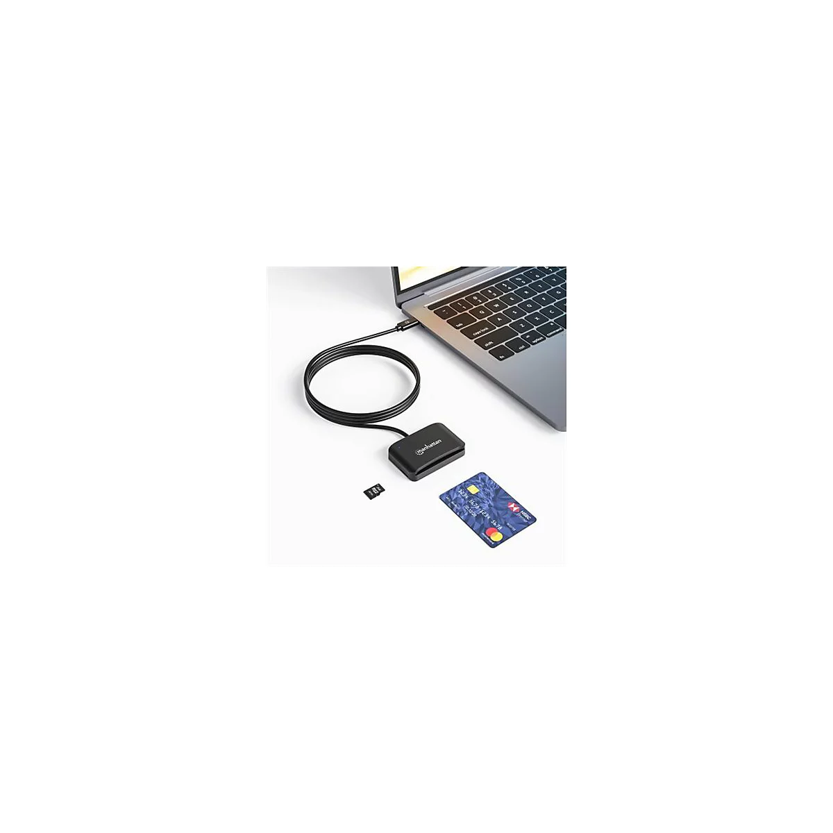 Manhattan Kartenlesegerät an einem Laptop angeschlossen, mit SD-Karte und Kreditkarte daneben auf weißem Tisch.
