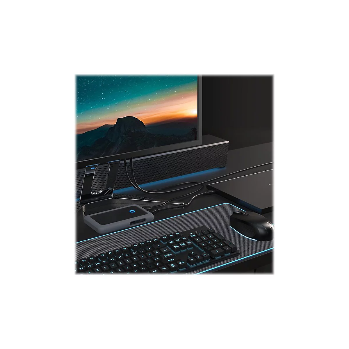 Schreibtisch mit Peripheriegeräten: Tastatur, Maus, Hub, Monitor. Alles schwarz mit blauen Akzenten.