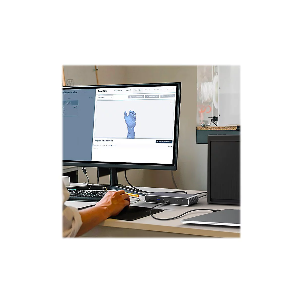 Person am Computer mit einem 3D-Modell einer Hand auf dem Bildschirm. PeripheriegerÃ¤te wie Tastatur und Maus liegen auf dem Schreibtisch.