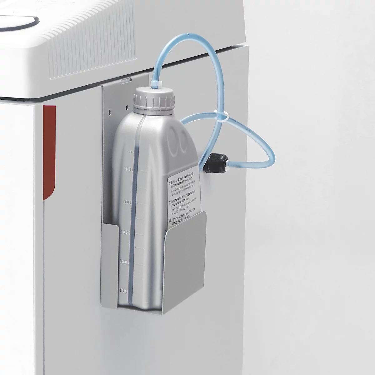 Detailaufnahme: An einer Maschine befestigte Flasche mit Schlauch. Aufkleber auf der Flasche.