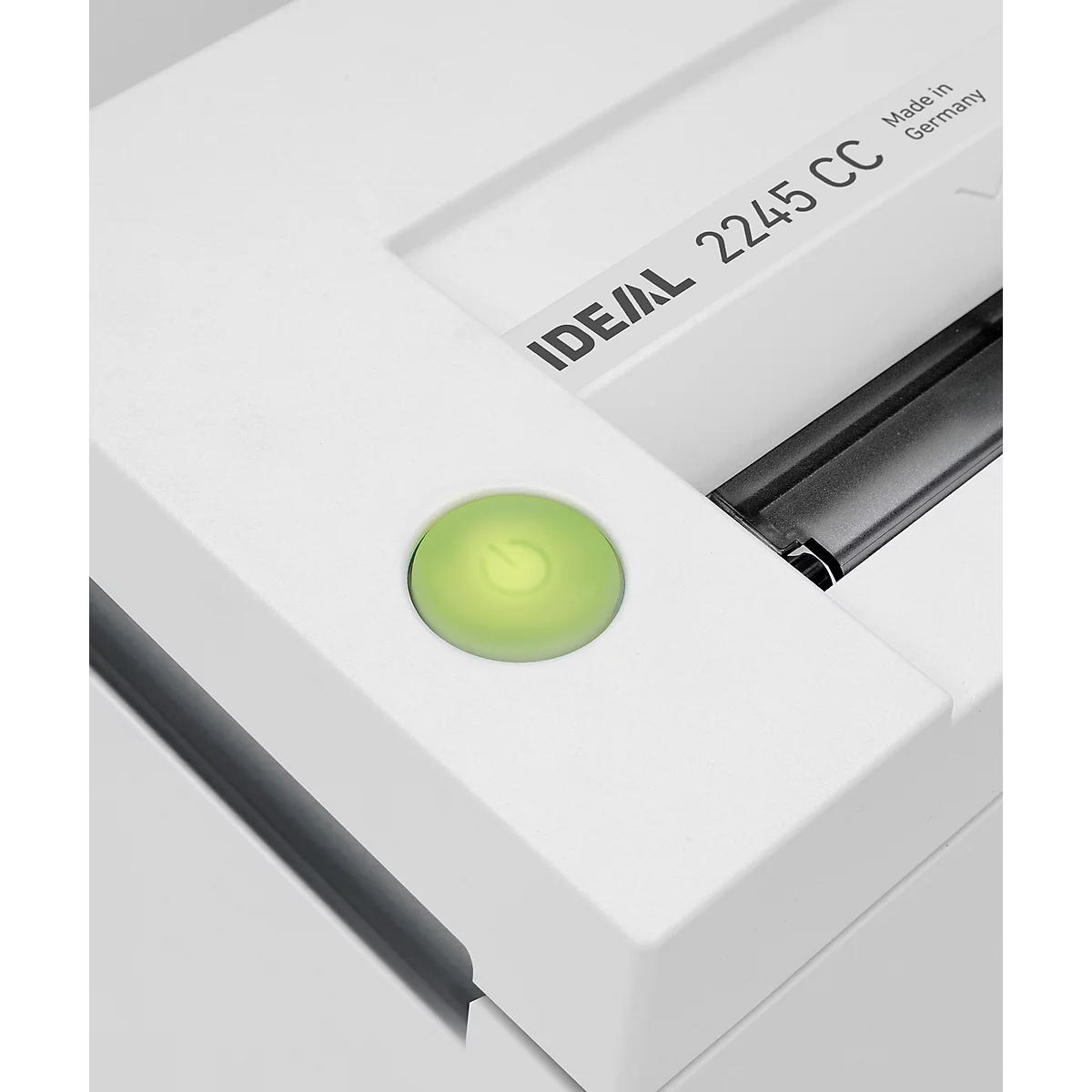 Close-up of a white paper shredder with a green power button.