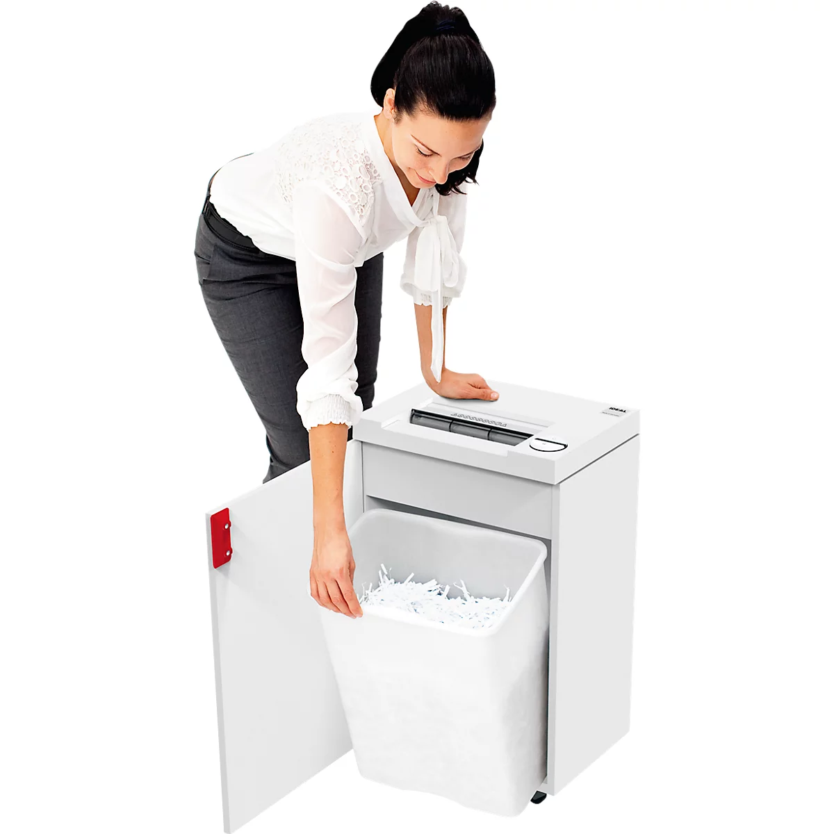 A woman empties a paper shredder. She opens the door and removes the full collecting container with shredded documents.