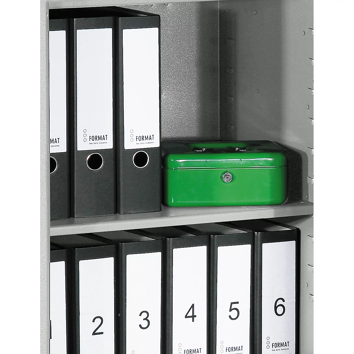 A steel cabinet with black folders and a green cassette. On the folders are white labels with the inscription FORMAT.