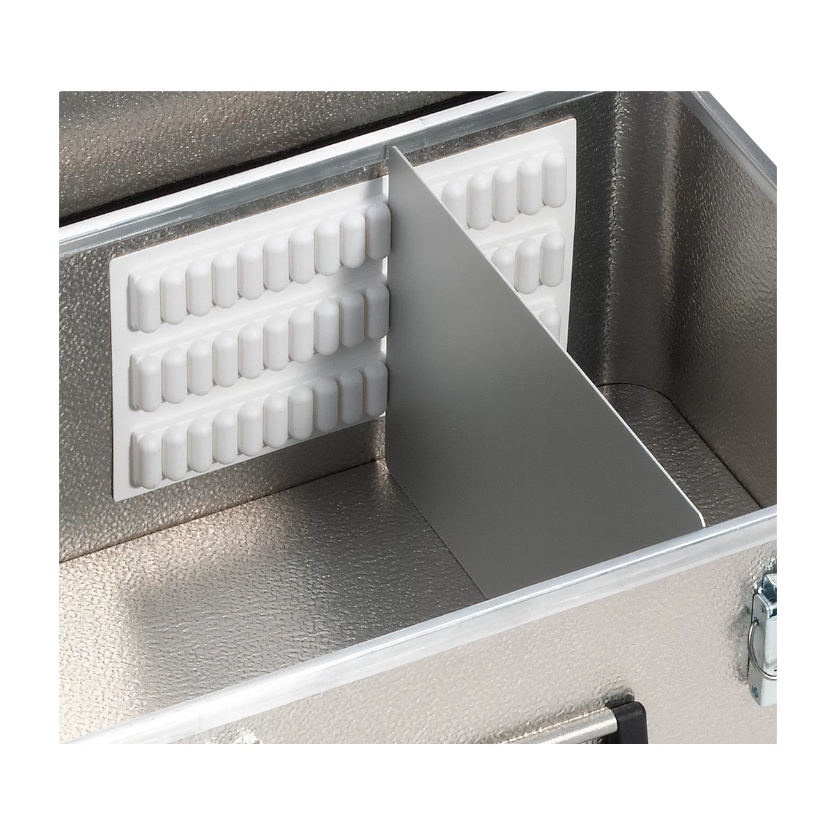 Detail of a silver case with internal dividers and white foam inserts.