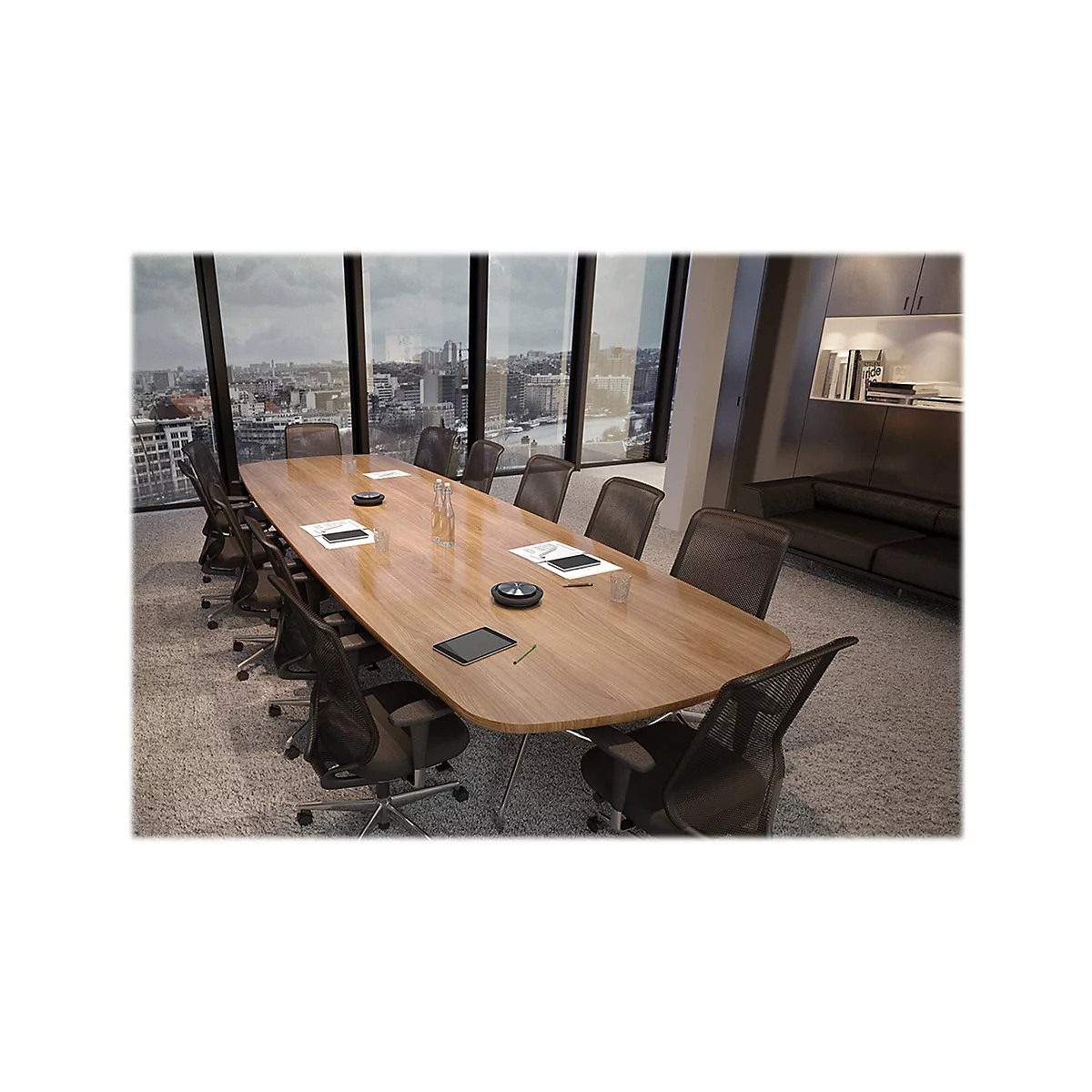 Une salle de confÃ©rence avec une table ovale en bois, entourÃ©e de chaises de bureau. De grandes fenÃªtres offrent une vue sur une ville.