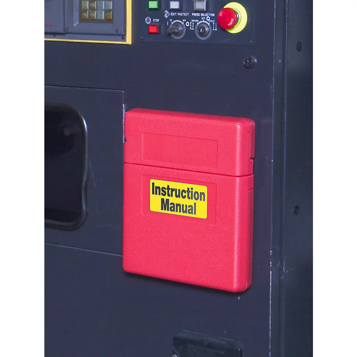 Roter Kasten mit „Instruction Manual“ an schwarzer Maschine.