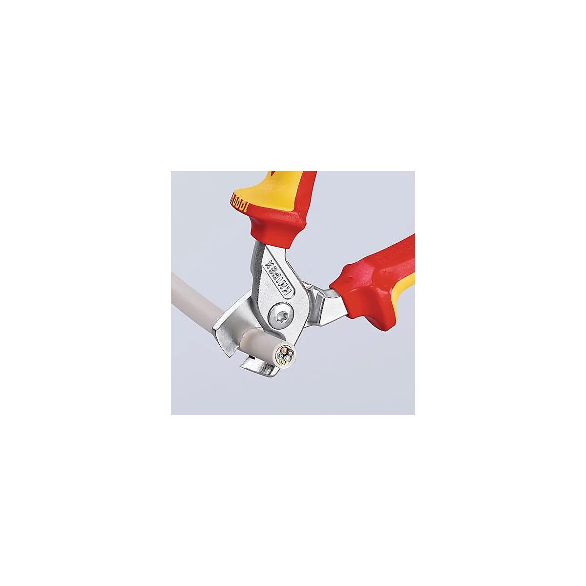 Een tang snijdt een kabel door. De tang heeft rood-gele handgrepen en zilveren snijvlakken. De kabel is wit met gekleurde draden.