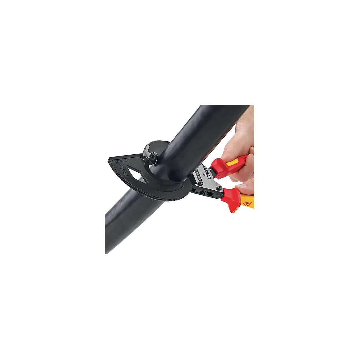 Persoon snijdt een zwarte kabel met een tang. De tool heeft rode en gele handgrepen en een zwarte geleider.