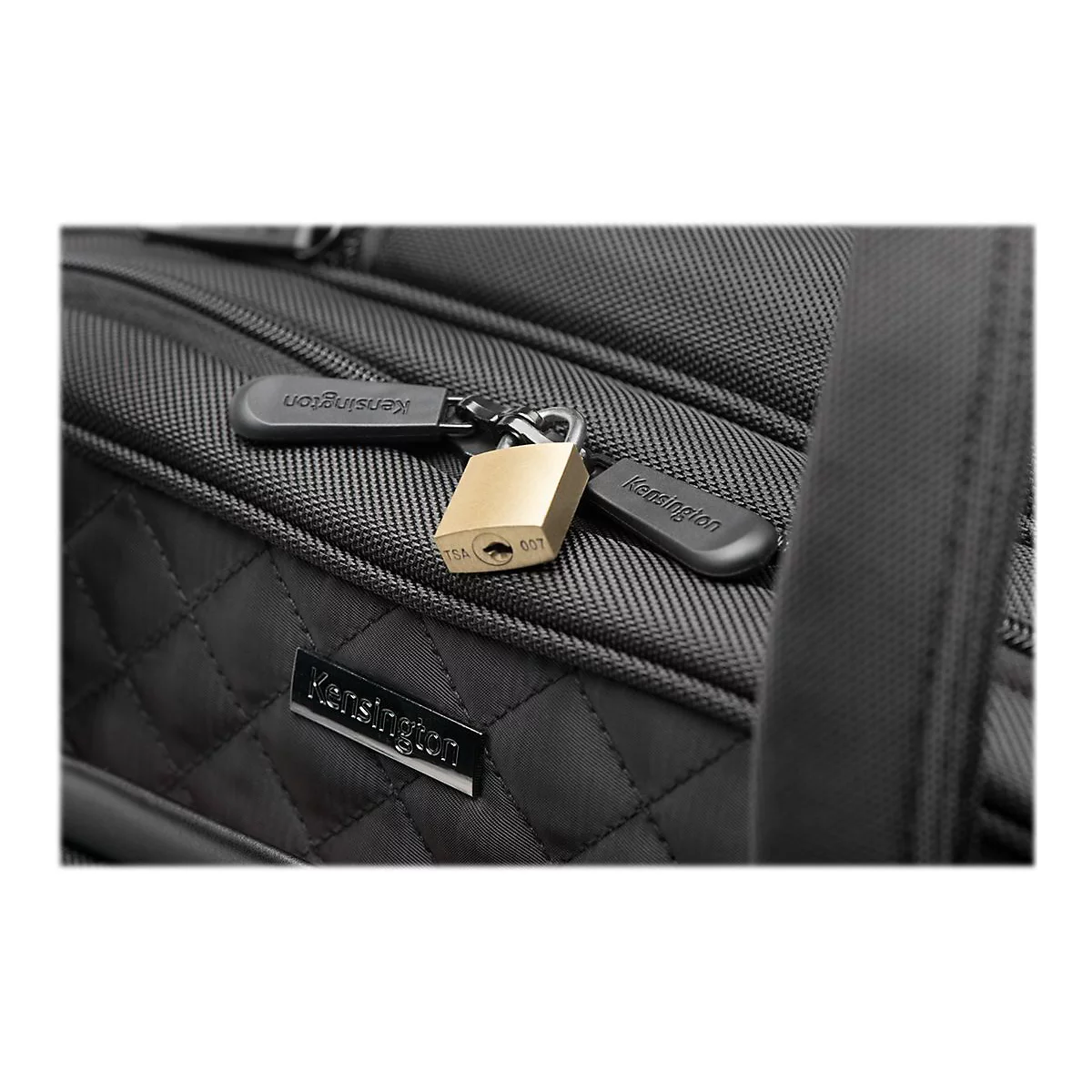 Detailaufnahme einer schwarzen Laptop-Tasche mit einem goldenen Vorhängeschloss, das mit einem Reißverschluss verbunden ist. Das Schloss trägt die Aufschrift 'TSA 007'.