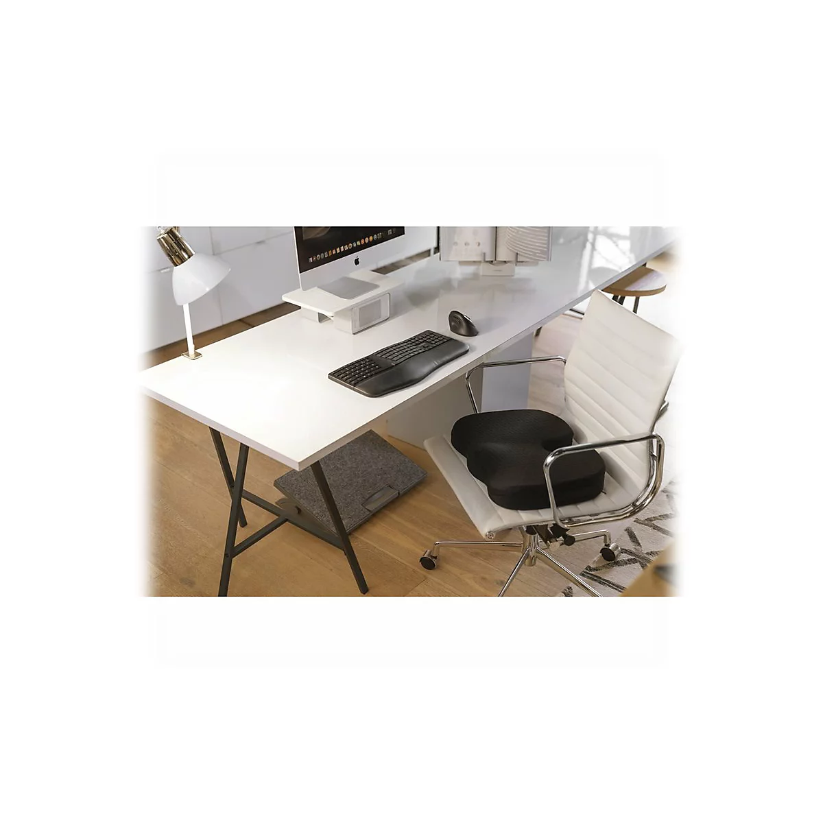 Un poste de travail avec bureau, ordinateur, clavier, souris et chaise avec coussin de siÃ¨ge.
