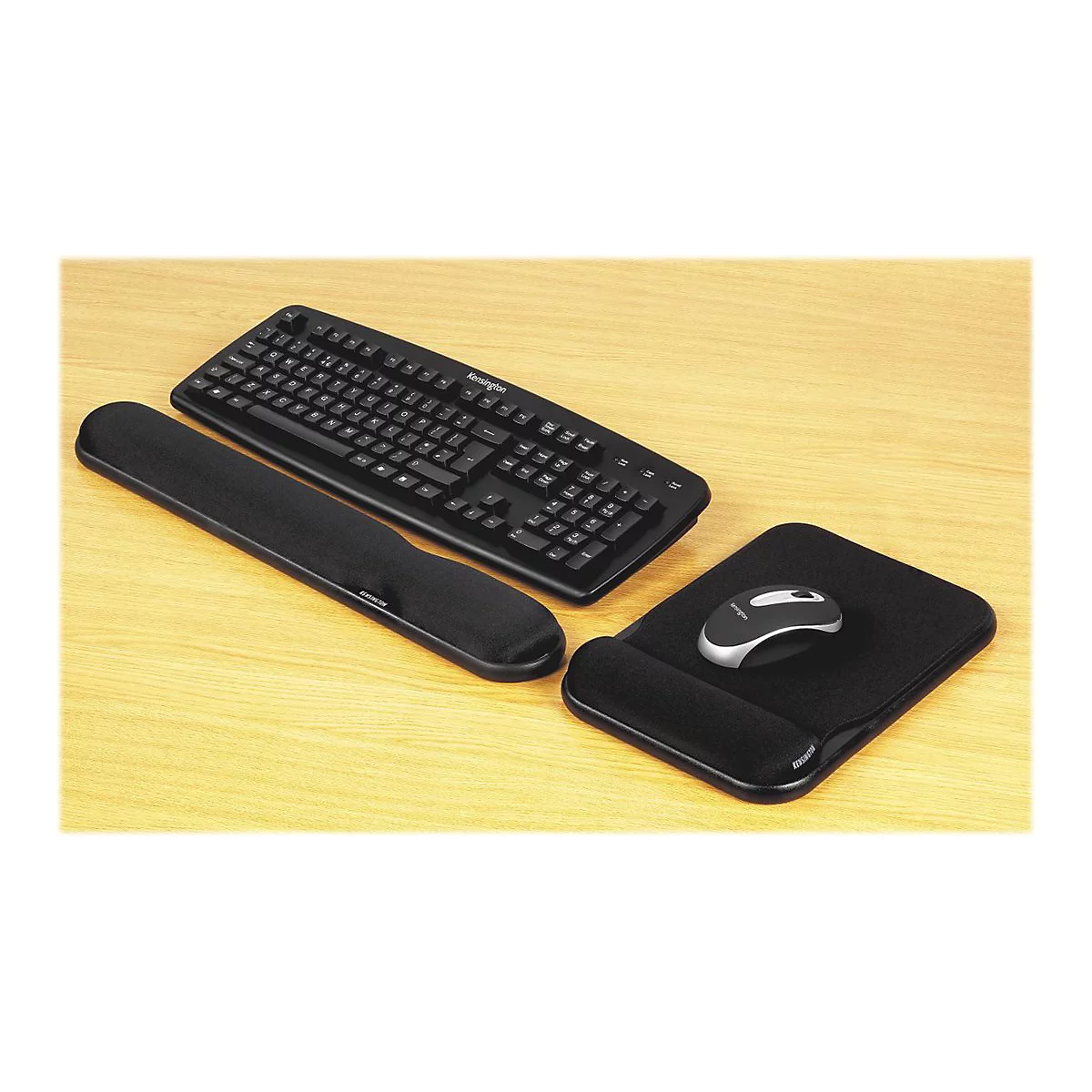 Schwarze Computertastatur, Handgelenkauflage und Mauspad mit Maus auf Holzoberfläche.
