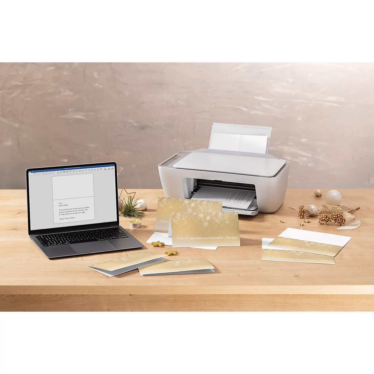 Op een houten tafel: laptop met tekst, printer, kaarten, decoratie.