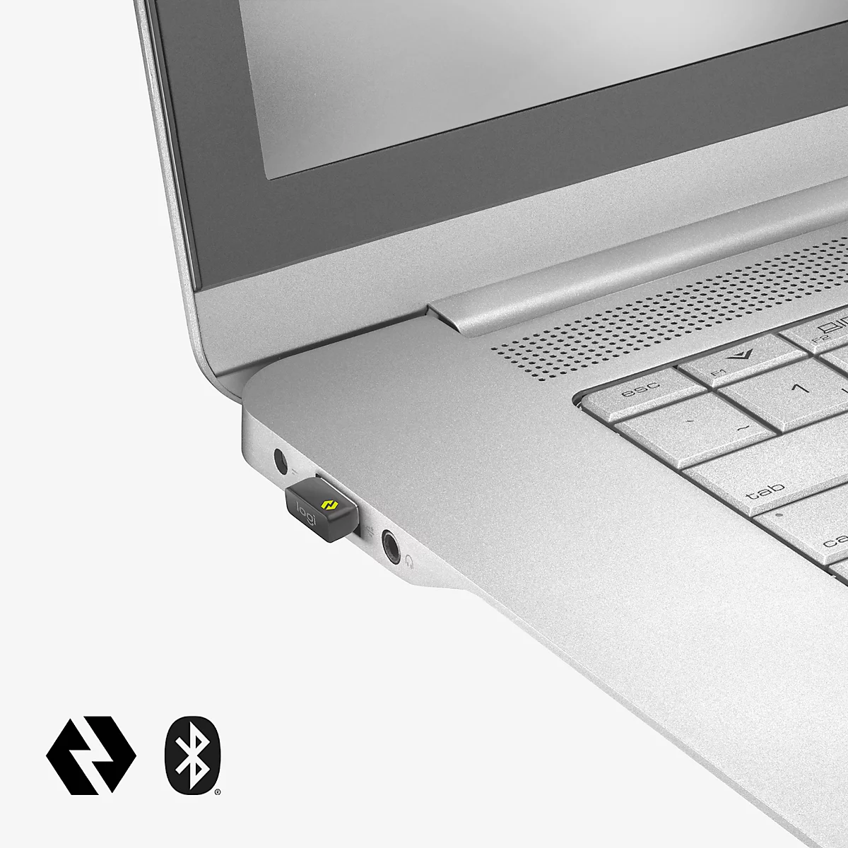 Close-up of a laptop with a Bluetooth dongle. The laptop is silver, the dongle is black with a green light. Two Bluetooth symbols.
