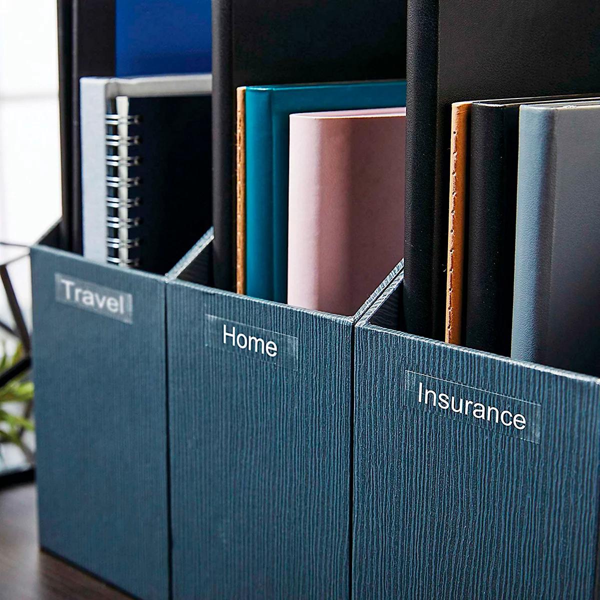 Trois porte-revues bleu foncé avec des dossiers étiquetés Travel, Home et Insurance.