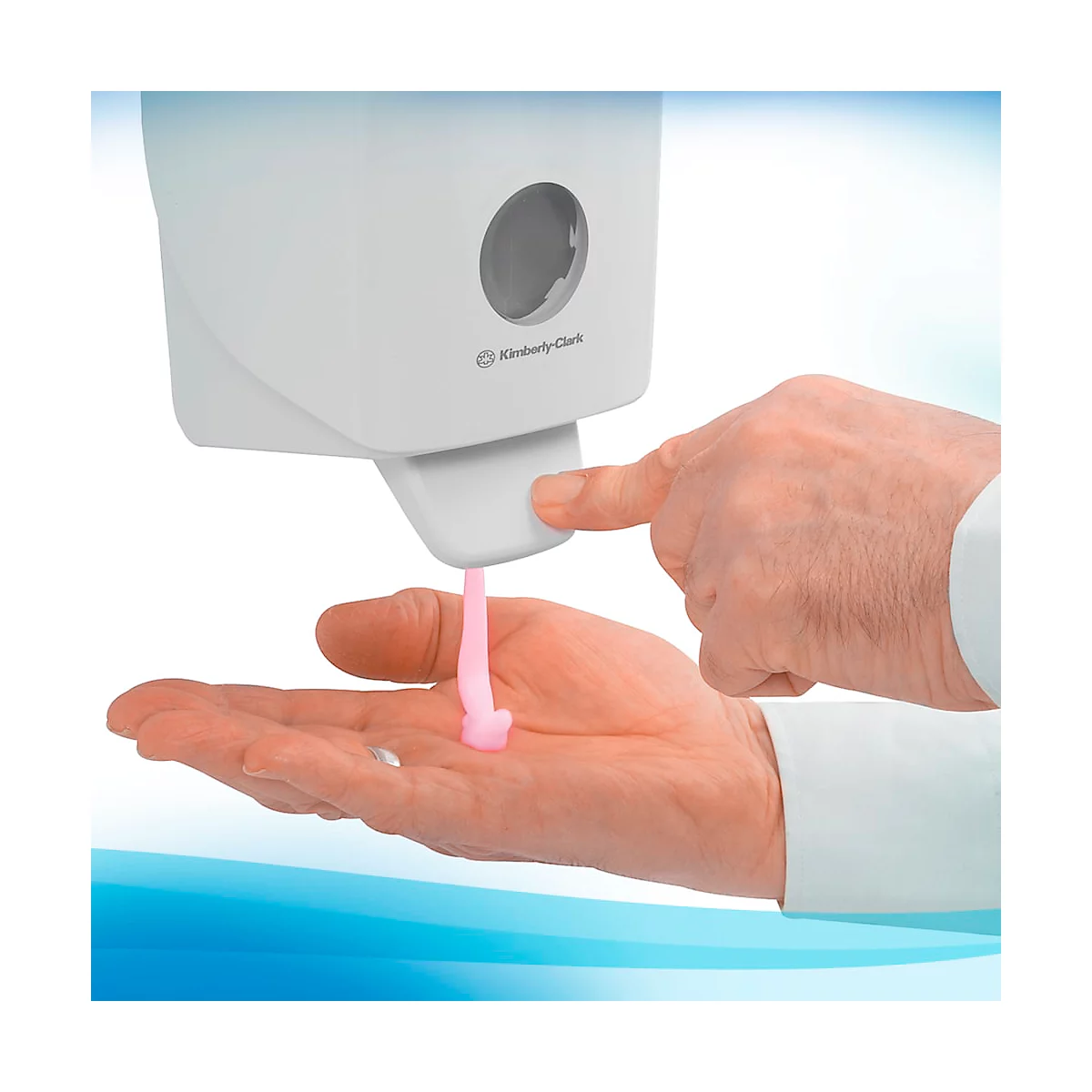 Dispensador de desinfectante de manos, persona accionando el dispensador, líquido rosa en la mano. Logotipo de Kimberly-Clark.