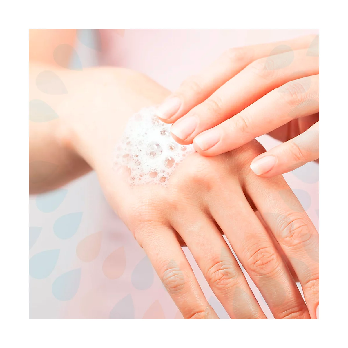 Gros plan sur une main recouverte de mousse savonneuse. Une autre main frotte doucement.