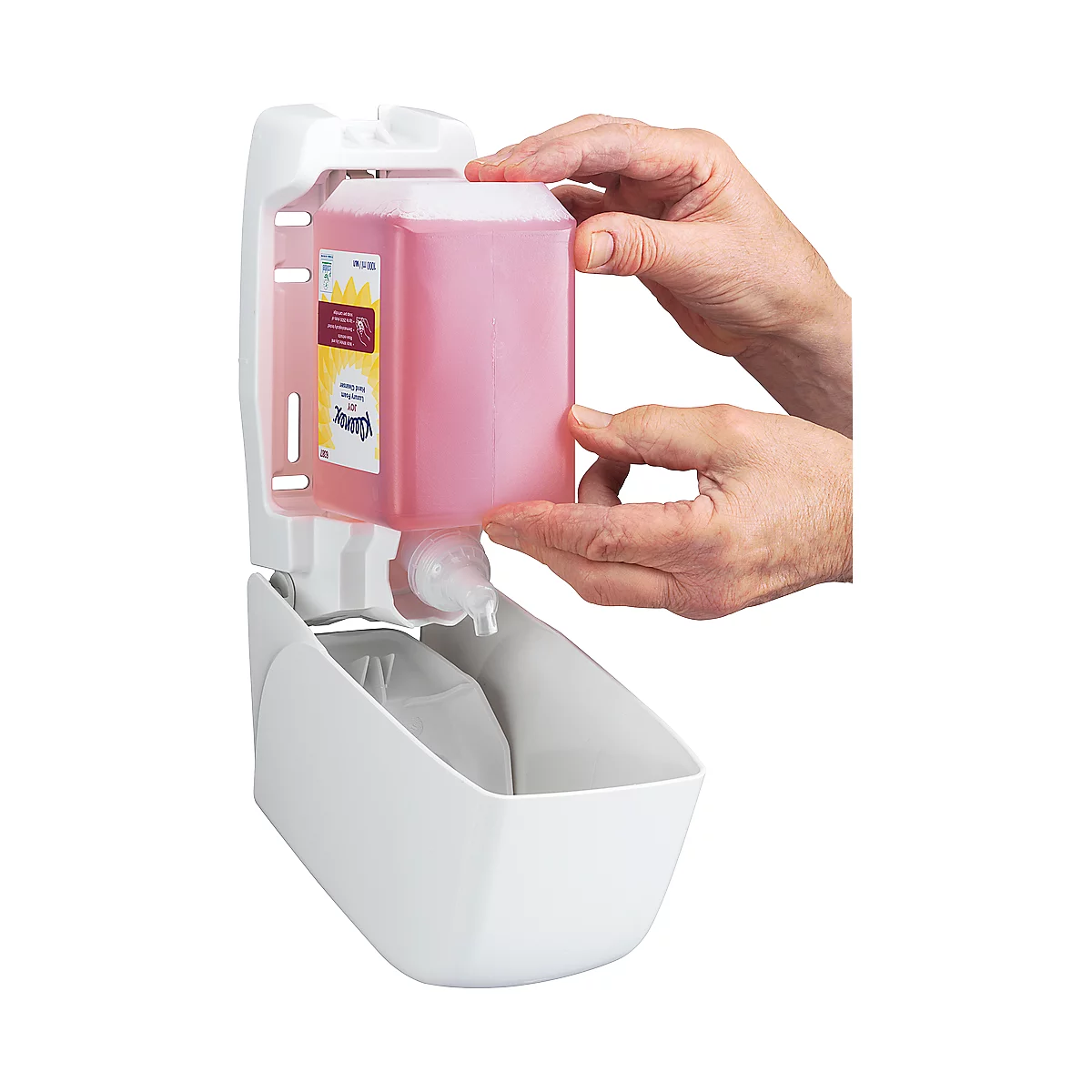 Hands holding a pink soap refill over a white soap dispenser.