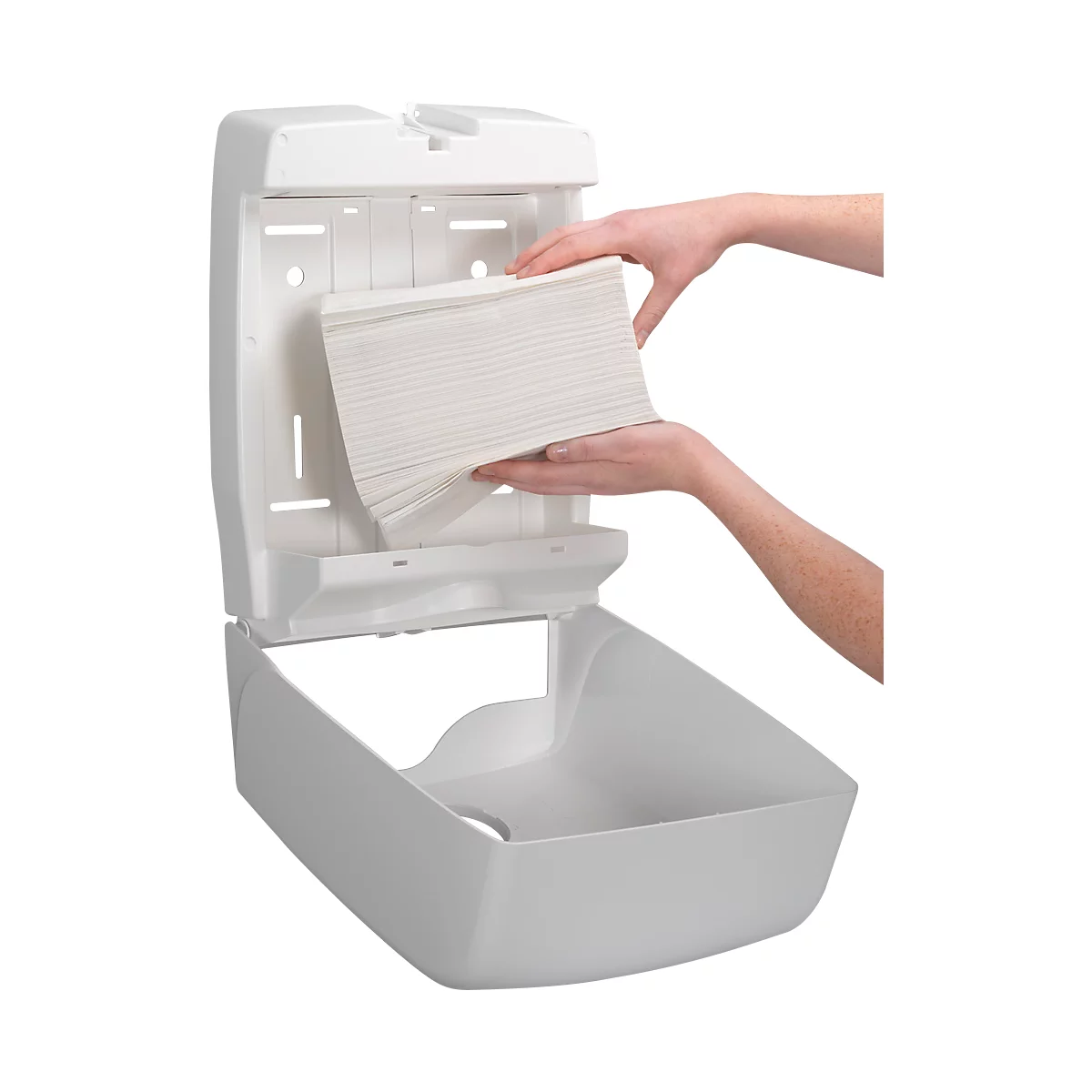 Person loading paper towels into a white paper towel dispenser.