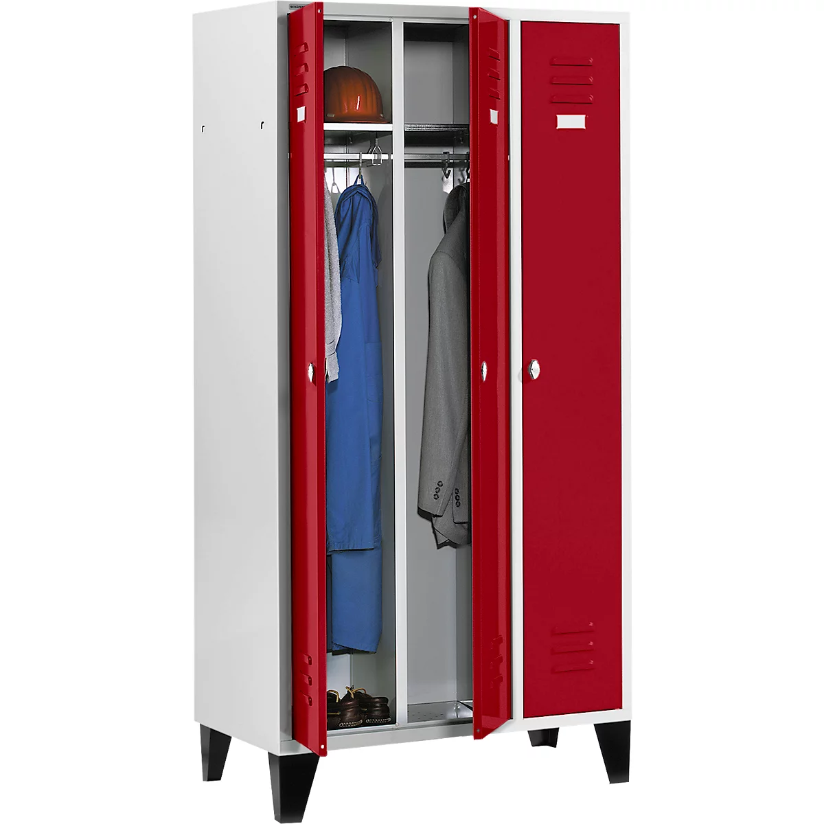 Weisser Schrank mit roten Türen, geöffnet. Kleidung und Helm sind sichtbar.